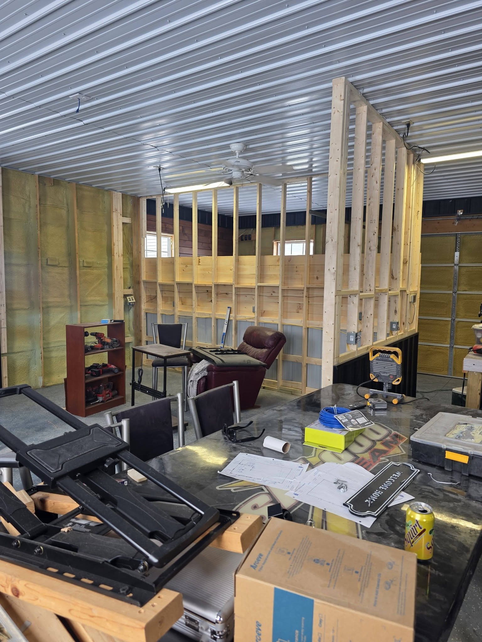 Pole barn mid-build, stud framing and insulation before simulator install